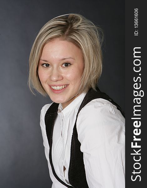 The beautiful, young girl-blonde in a white blouse and a dark waistcoat. The beautiful, young girl-blonde in a white blouse and a dark waistcoat