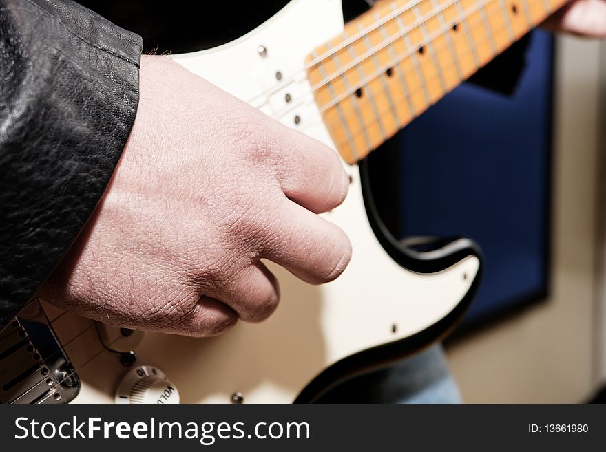 A guitar player's hand while playing an electric guitar. A guitar player's hand while playing an electric guitar