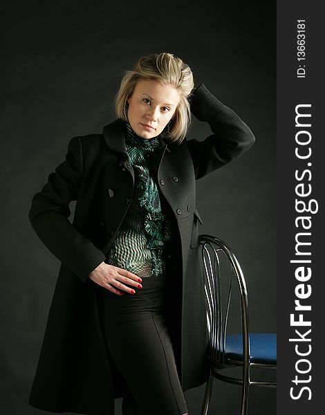 Portrait of the beautiful, young girl-blonde in a green transparent blouse and a black coat. Portrait of the beautiful, young girl-blonde in a green transparent blouse and a black coat