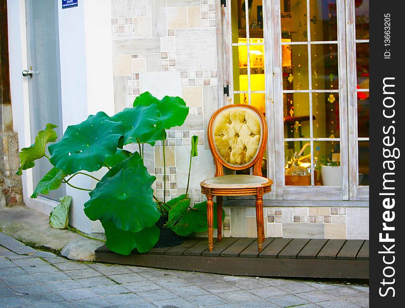 The chair of a retro stands in the street under a window. The ex-terrier