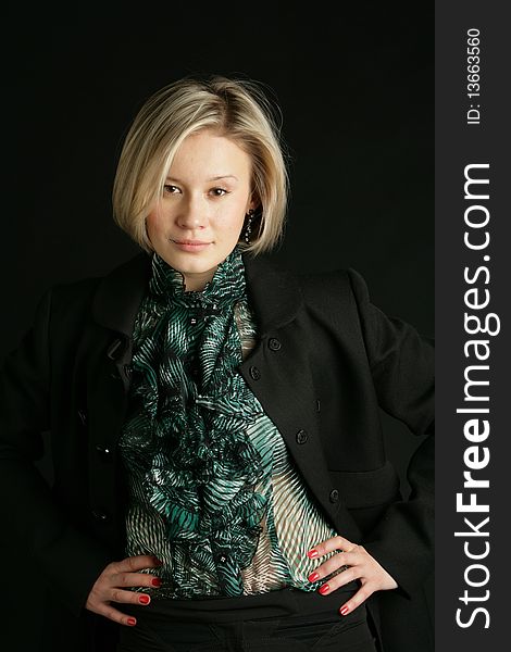 Portrait of the beautiful, young girl-blonde in a green transparent blouse and a black coat. Portrait of the beautiful, young girl-blonde in a green transparent blouse and a black coat