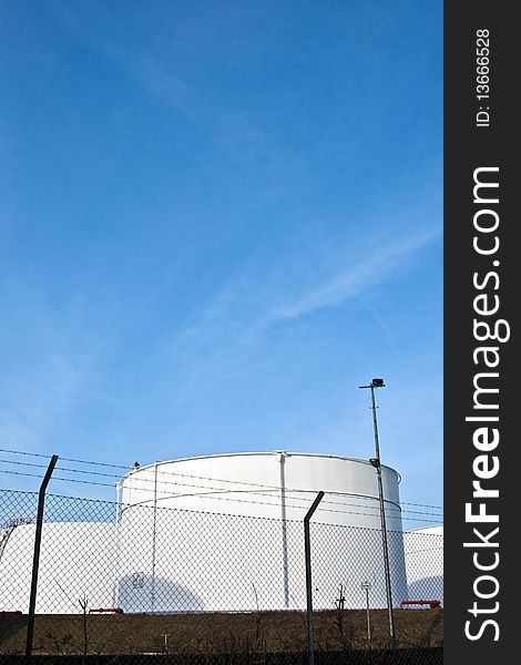 White tanks in tankfarm with staircase to enter the construction with blue sky, storage of petrol, oil. White tanks in tankfarm with staircase to enter the construction with blue sky, storage of petrol, oil