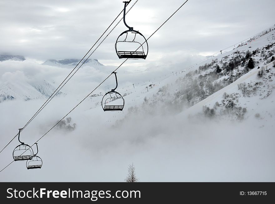 Empty ski-lift coming from the valley in the fog. Empty ski-lift coming from the valley in the fog