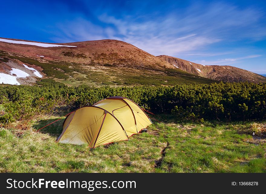 Camping in mountains. A solar landscape with tourist tent