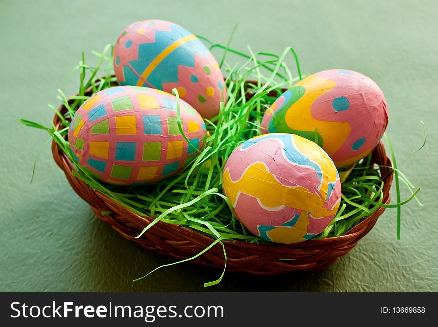 Yellow Easter eggs in a basket on green background