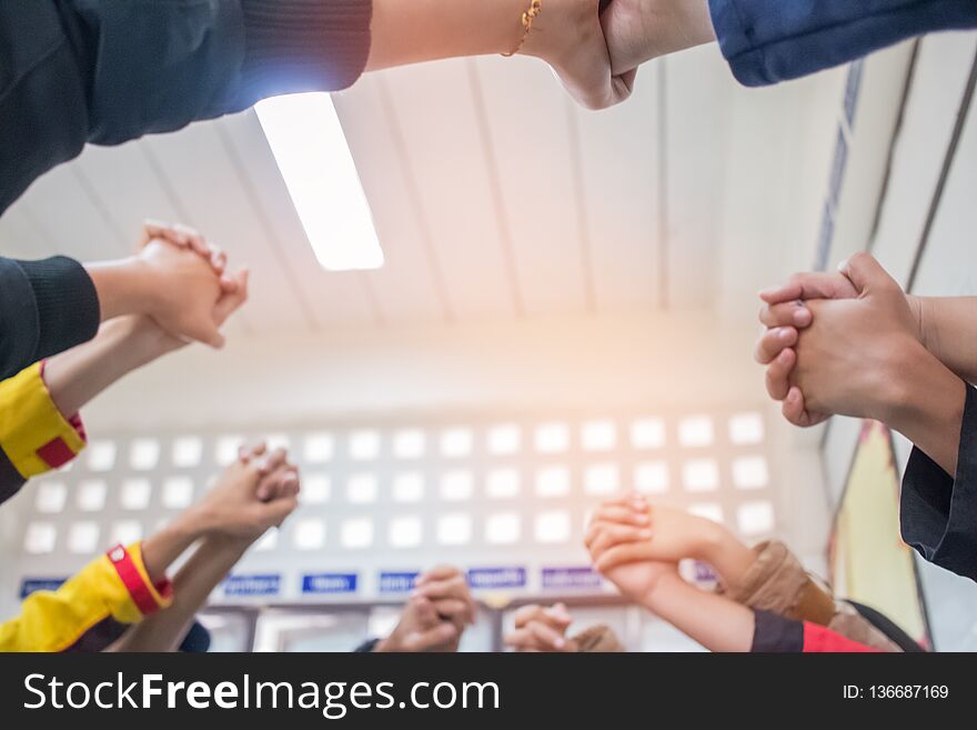 Unity and teamwork Concept: Blurred of Group students hands together in classroom. View of Asian young men putting their hand
