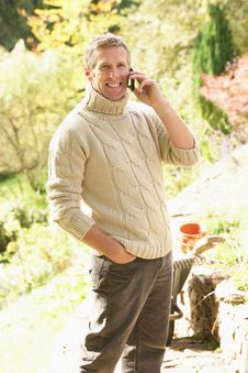 Man Outdoors On Mobile Phone In Garden Royalty Free Stock Photography Man Outdoors On Mobile Phone In Garden Royalty Free Stock Photography