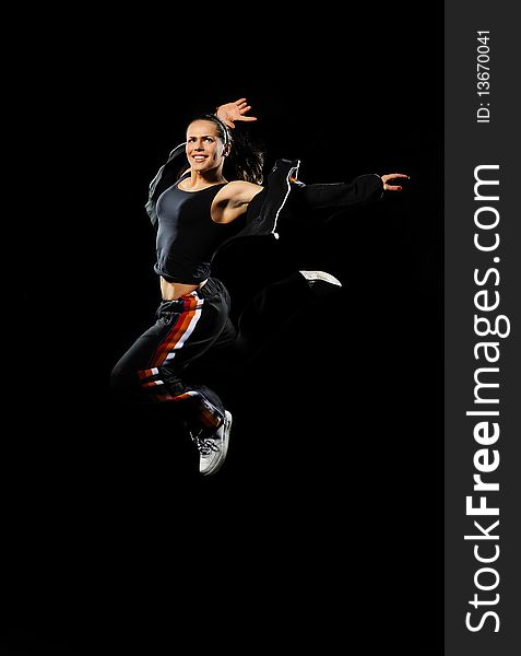 Female dancer jumping on a black background