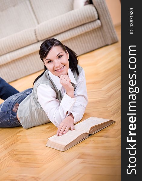 Youing brunette woman reading book at home