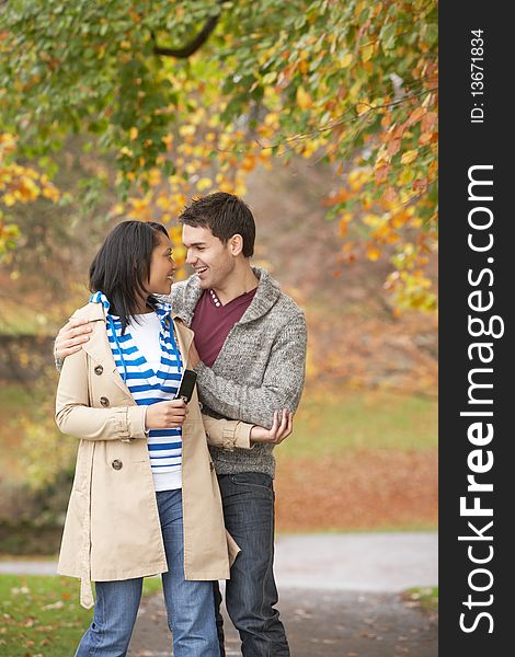 Romantic Teenage Couple In Autumn Park smiling