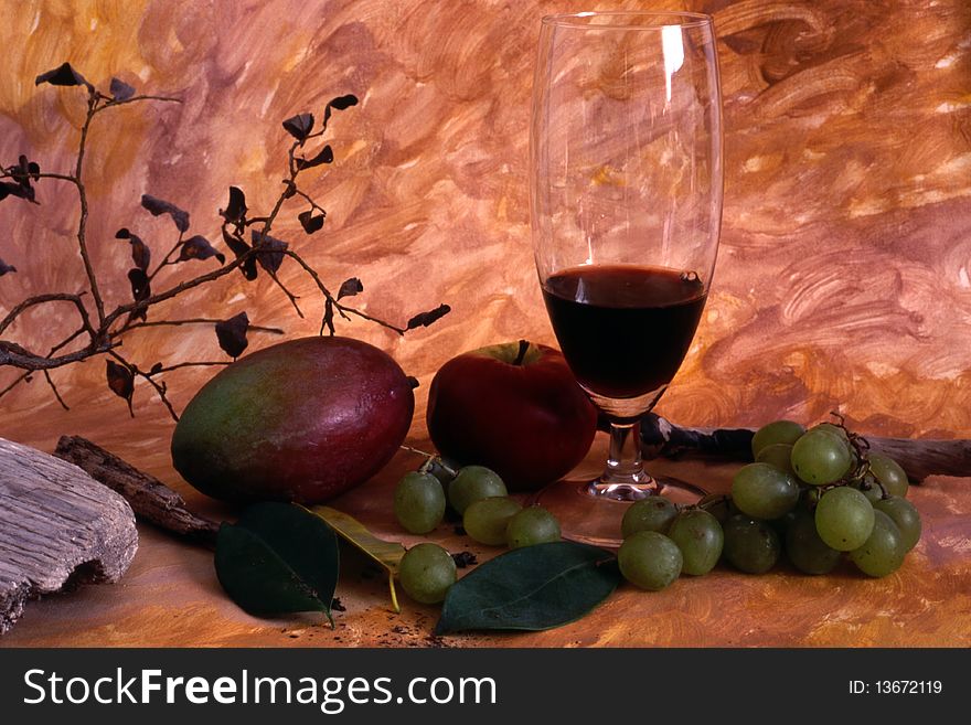 A glass red wine and fruits isolated on painted background