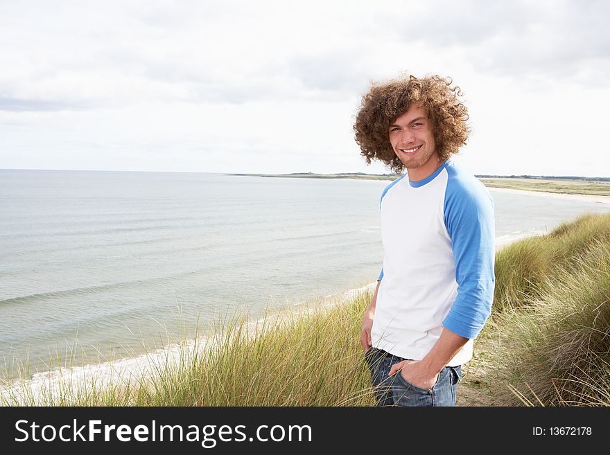 Young Man Standing In Sand Dunes and smiling