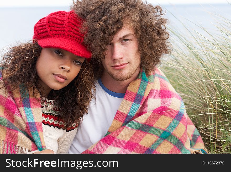 Young Couple Sitting In Sand Dunes