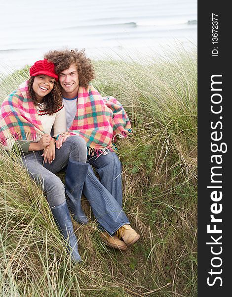 Young Couple Sitting In Sand Dunes