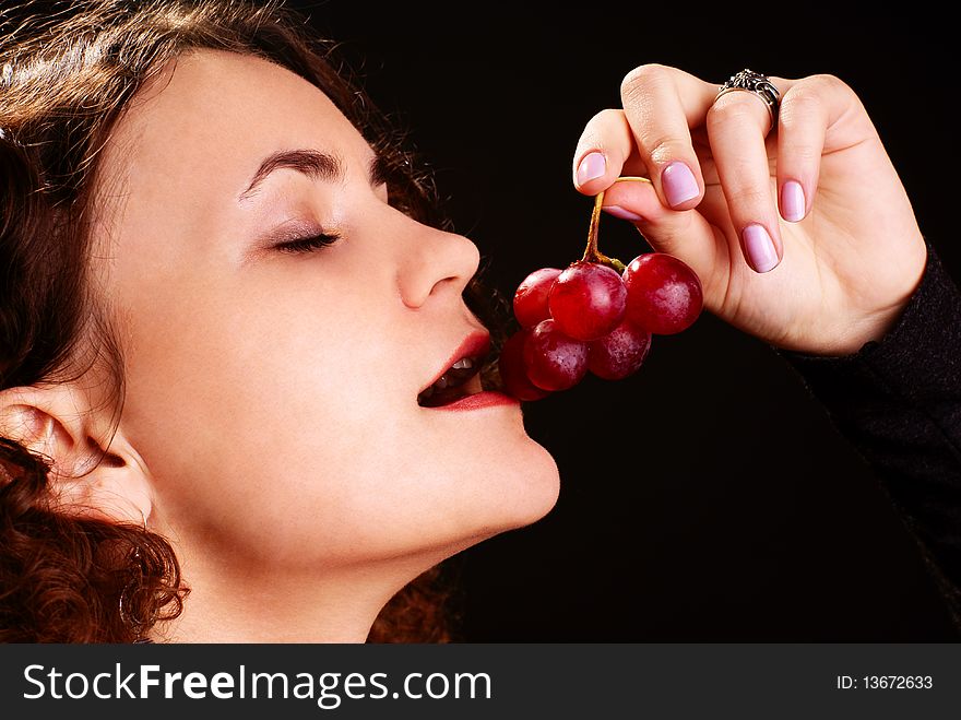 Portrait of a young beautiful woman eating grapes. Portrait of a young beautiful woman eating grapes