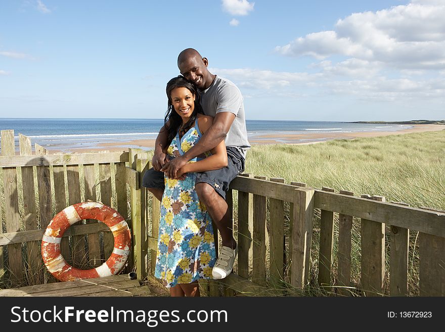 Romantic Young Couple Standing By Wooden Fence