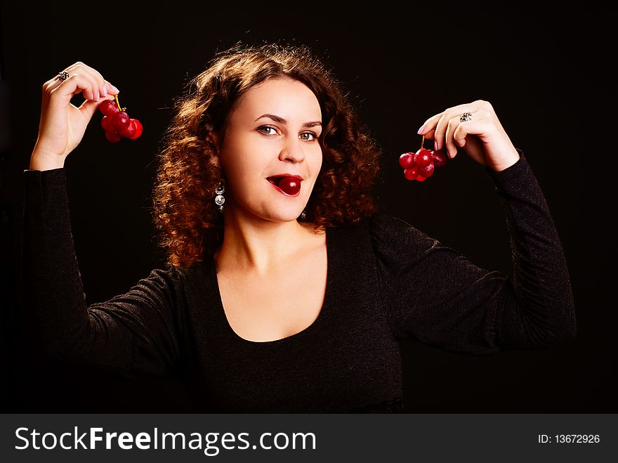 Portrait of beautiful woman with grapes. Black background. Studio shot.