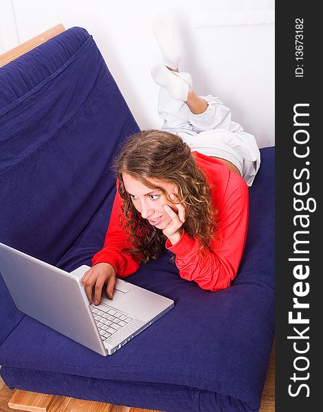 Nice girl work on laptop lying on the sofa. Nice girl work on laptop lying on the sofa