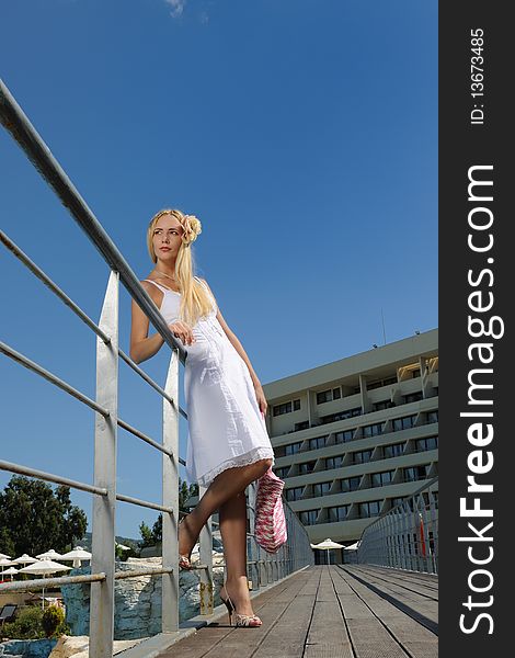 The fashionable young woman in a white dress outdoors. The fashionable young woman in a white dress outdoors