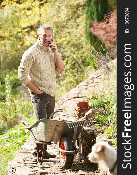Man Outdoors On Mobile Phone With Dog