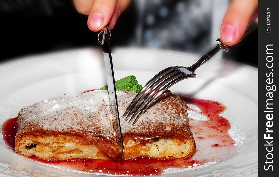 Close up shot of an apple pie which is served for business lunch decorated by sugar powder and strawberry jam. Close up shot of an apple pie which is served for business lunch decorated by sugar powder and strawberry jam