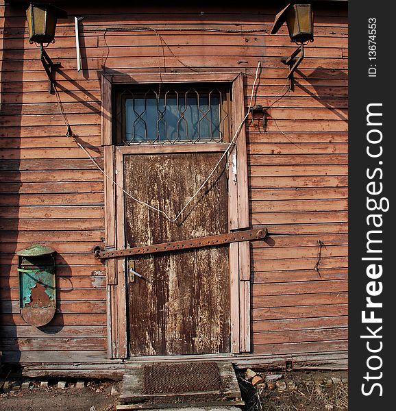 A old wooden door with two lamps.