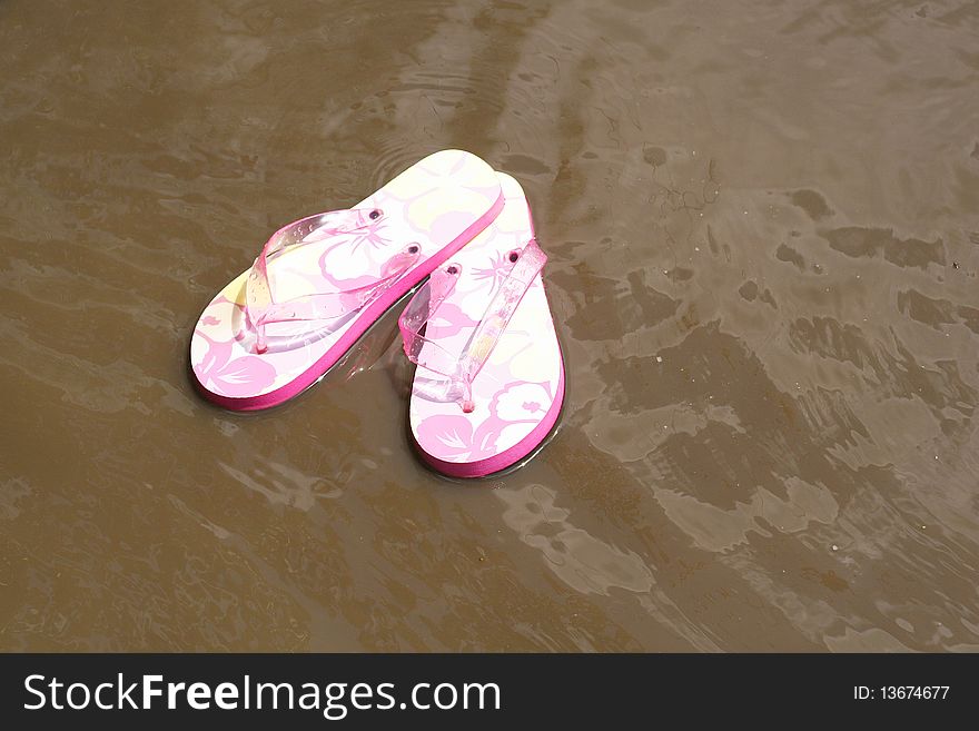 Shot of floating flip flops in the water