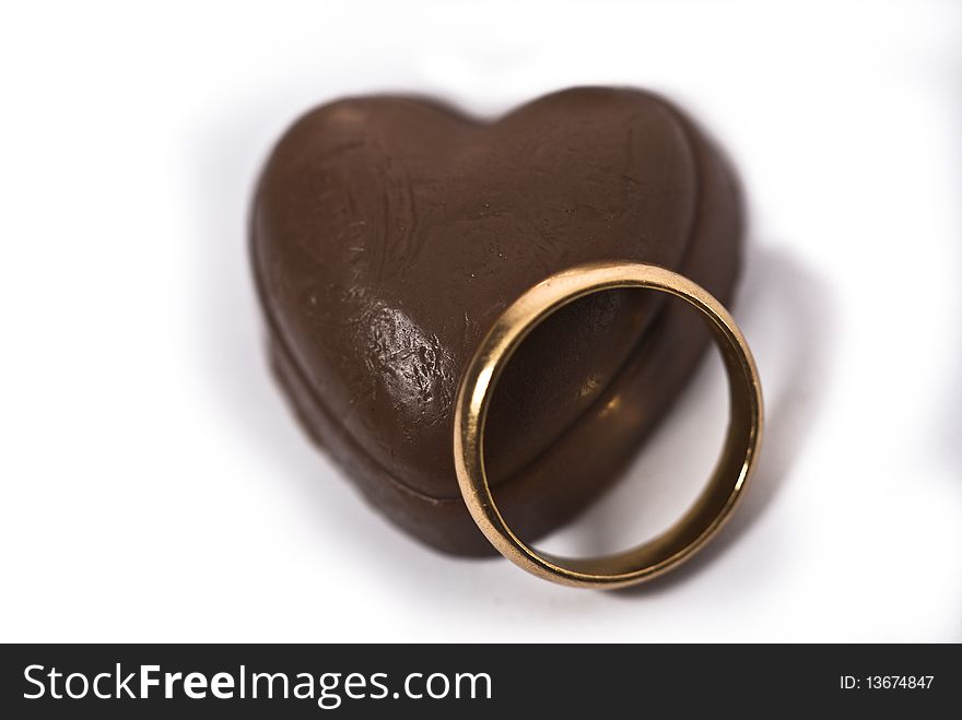 A ring and a heart shaped chocolate - symbolising love commitment. A ring and a heart shaped chocolate - symbolising love commitment