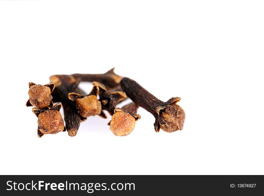 Heap of dry aroma cloves on white background. Shallow depth of field.