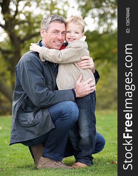Father And Son Hugging On Outdoor Autumn Walk. Father And Son Hugging On Outdoor Autumn Walk