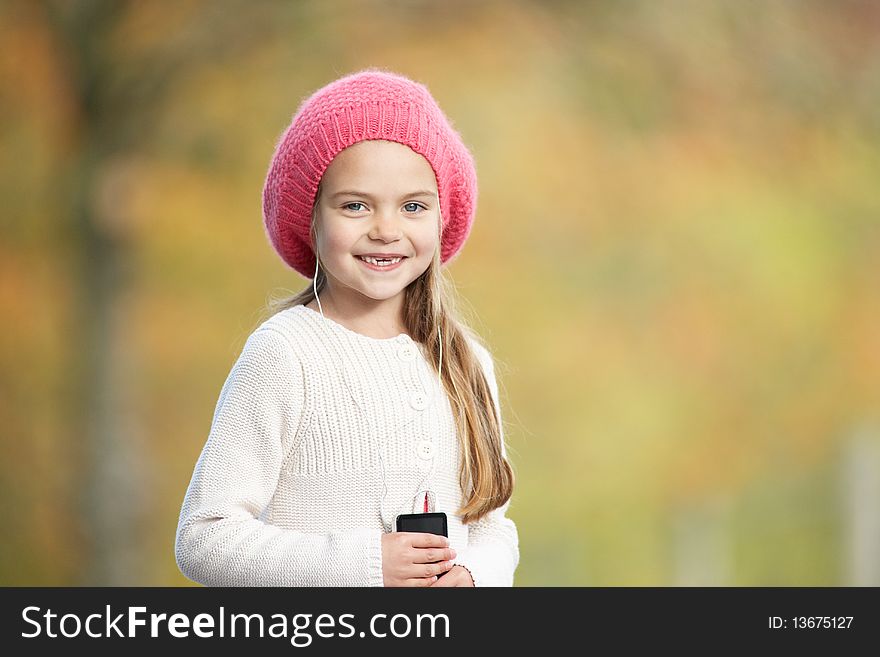 Young Girl Outdoors With MP3 Player Looking At Camera