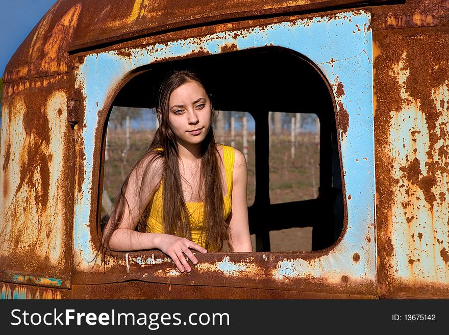 Young woman at the window of an old, rusty bus. Young woman at the window of an old, rusty bus