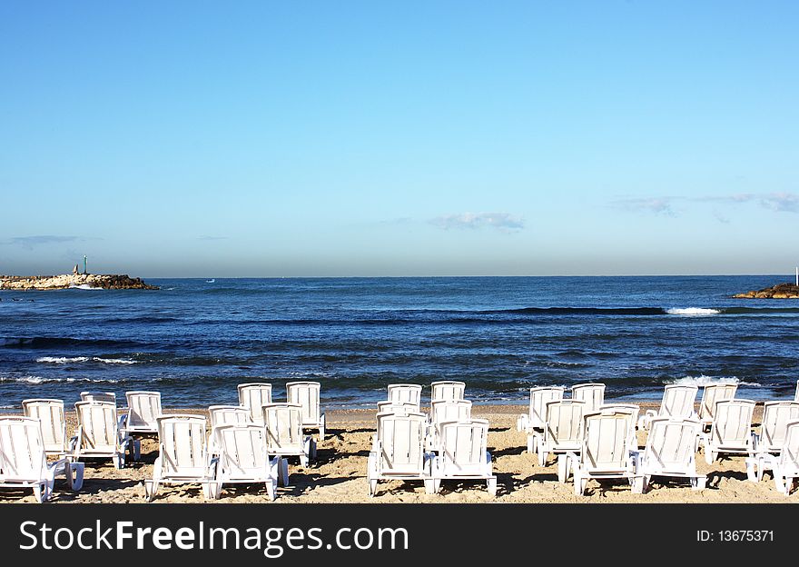 White deck chairs on the background of blue sea. White deck chairs on the background of blue sea