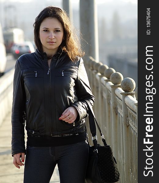 Young caucasian brunette woman staying on bridge. Young caucasian brunette woman staying on bridge