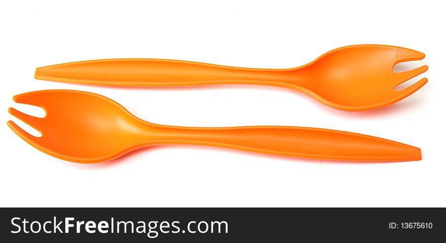 Two plastic orange forks on white background
