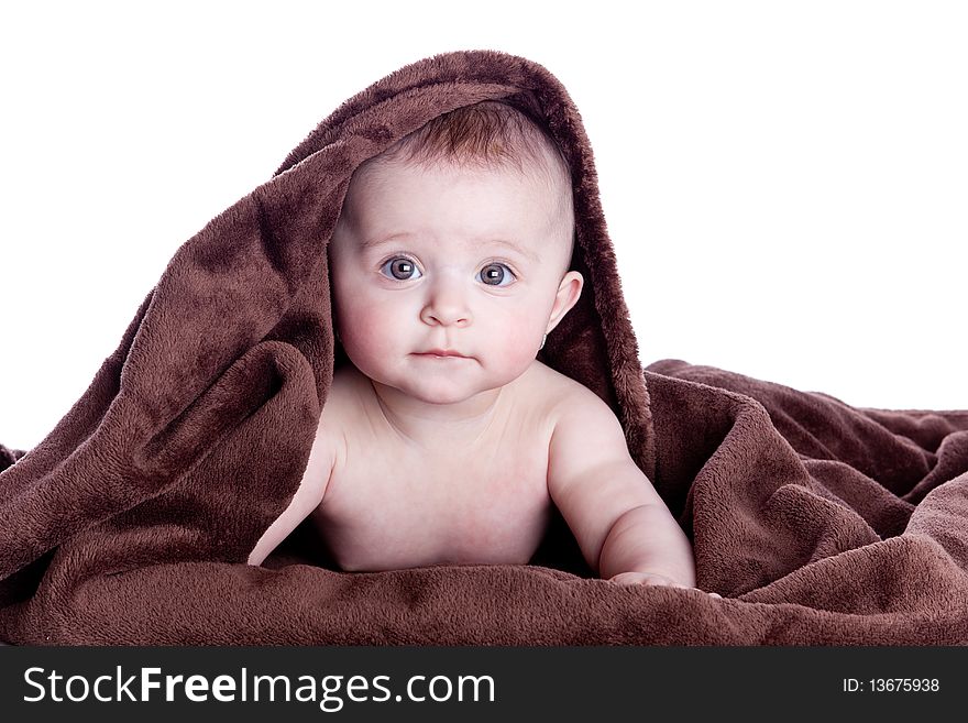 A beautiful baby under a brown towel on white background