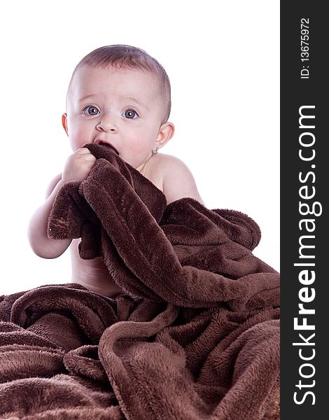 A beautiful baby under a brown towel on white background