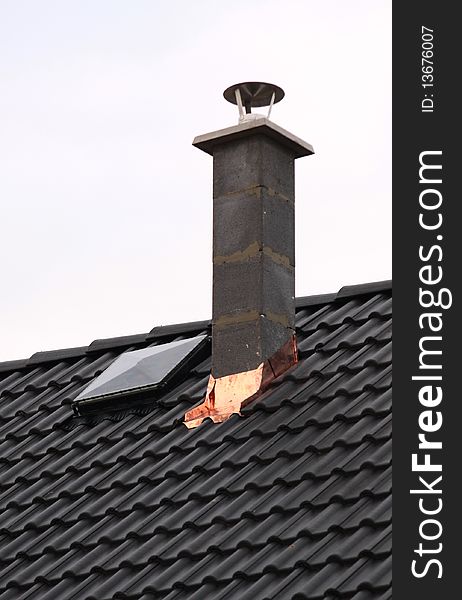 Chimney on black roof. new house