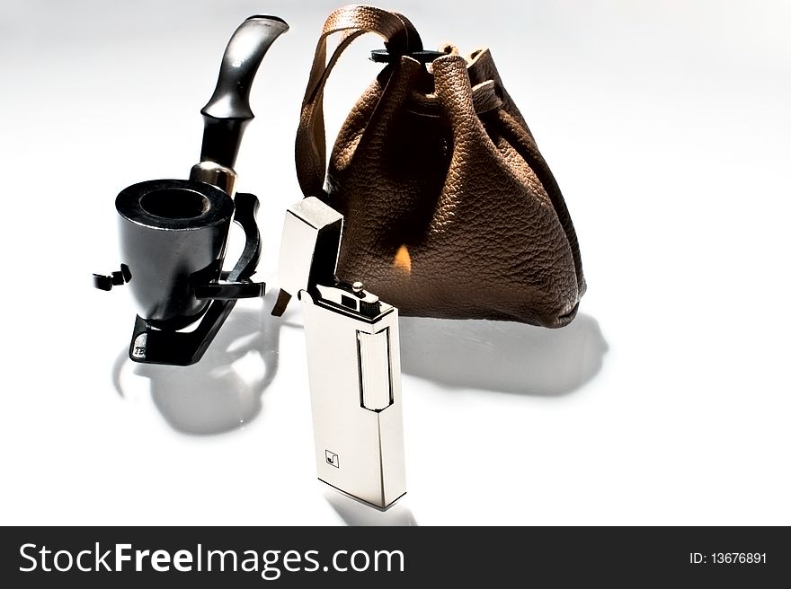 Pipe, tobacco pouch and pipe lighter isolated on a white background. Pipe, tobacco pouch and pipe lighter isolated on a white background