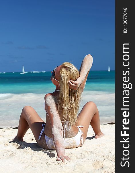young woman in white bikini relaxing on tropical beach. young woman in white bikini relaxing on tropical beach