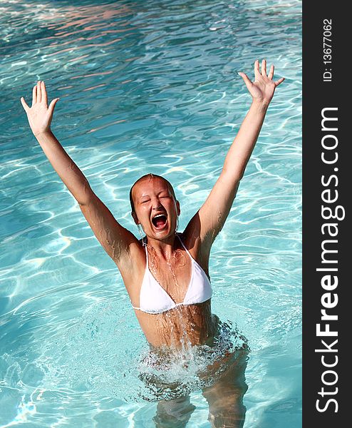 young female jumping out of water in swimming pool,enjoying good time