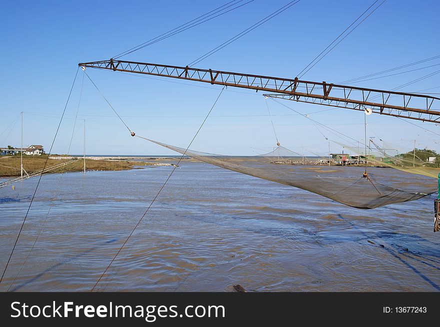 Large lift nets at the outfall of a river. These nets are operated from stationary installations situated along the shore. Large lift nets at the outfall of a river. These nets are operated from stationary installations situated along the shore.