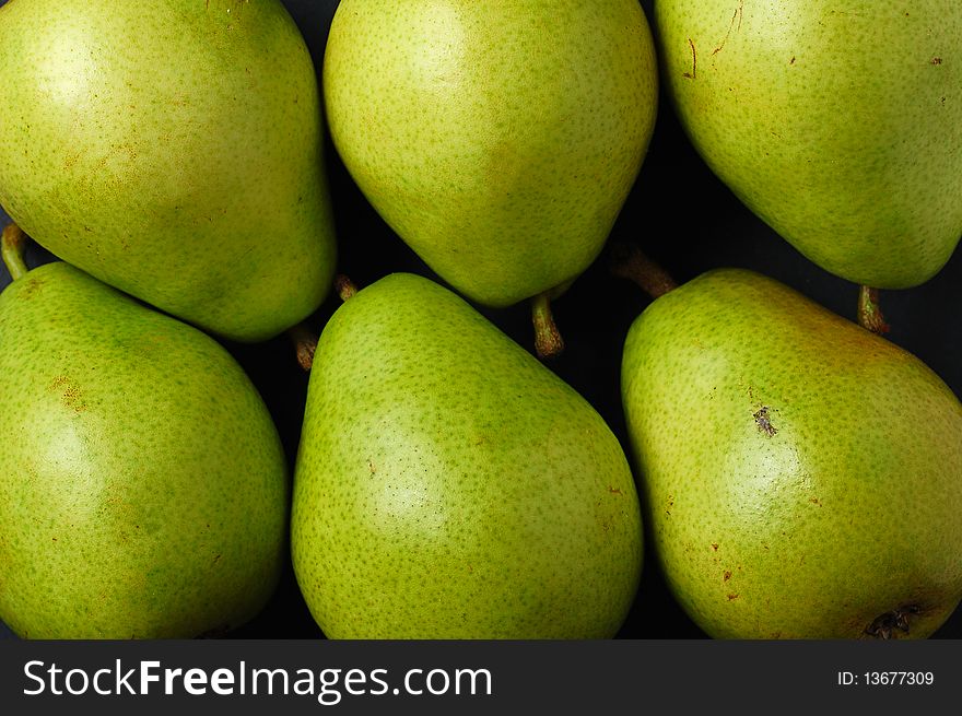 Various green pears on black background