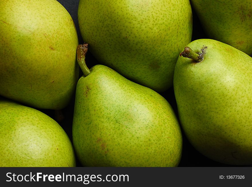 Various green pears on black background