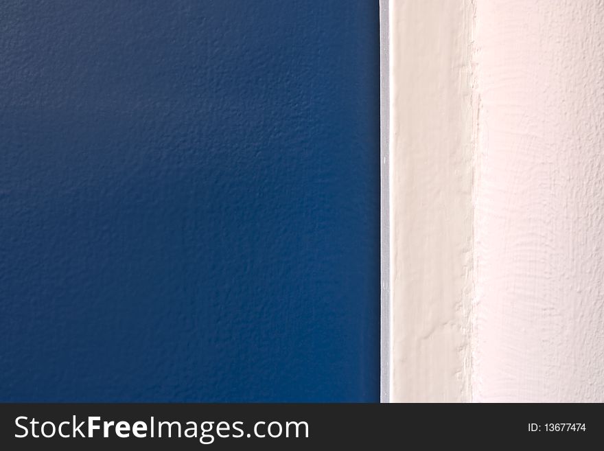 A close-up of a blue painted door and a white painted wall. A close-up of a blue painted door and a white painted wall