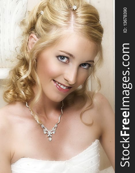 Beautiful Blond bride wearing diamond jewelery and a white gown