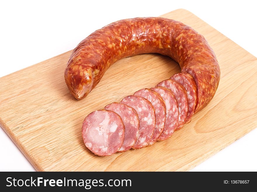Smoked sausage slices on wooden plate