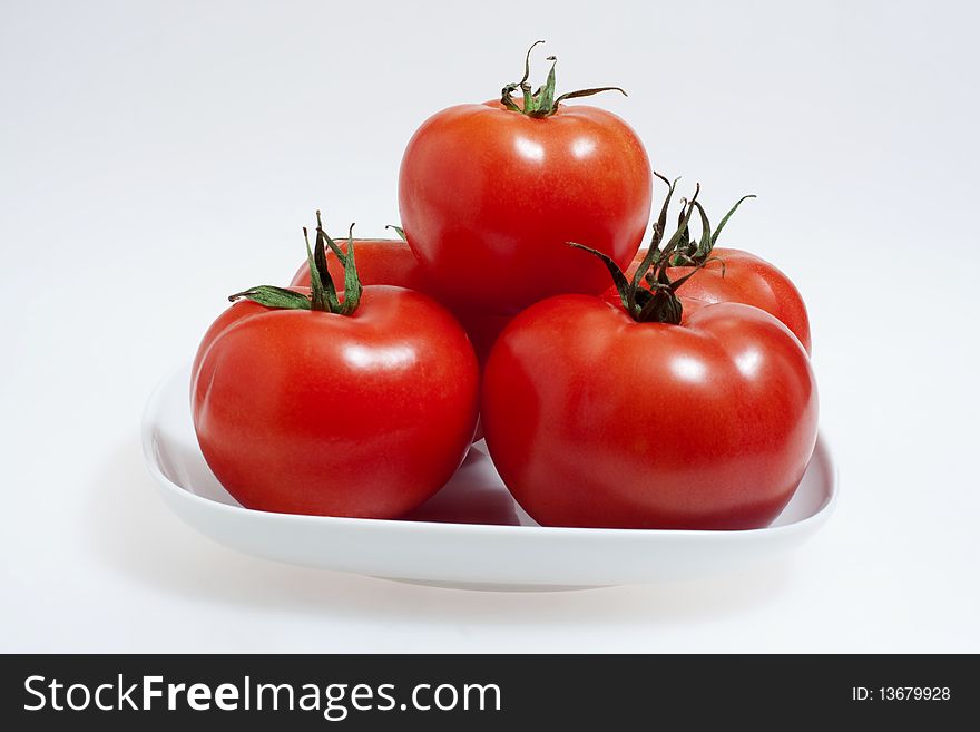 Red tomatoes on a white plate