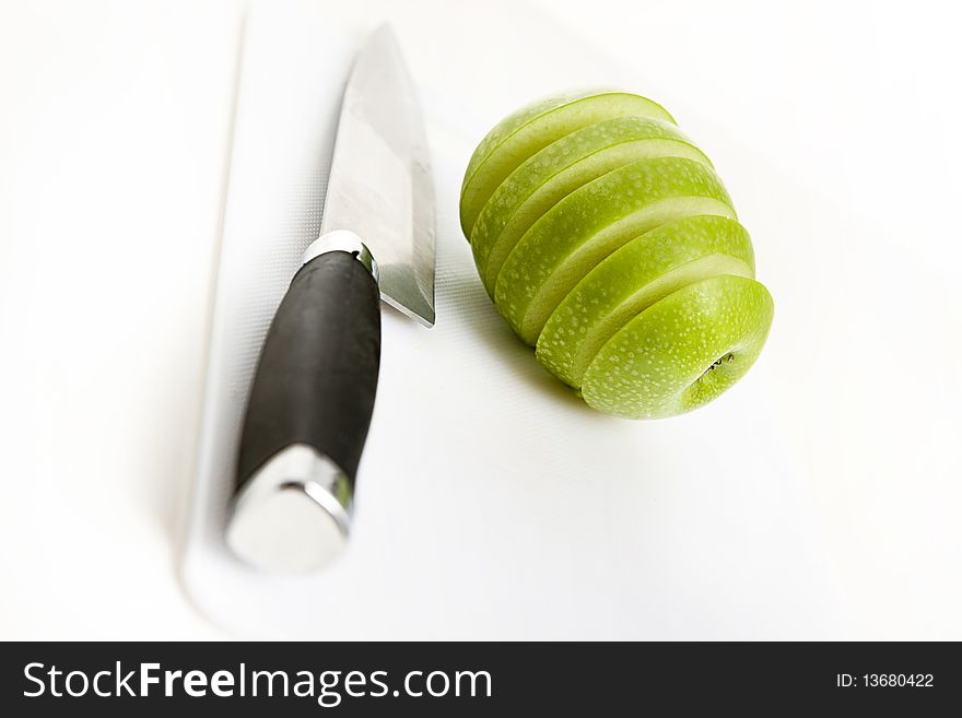 Sliced green apple in multiple peices with knife. Sliced green apple in multiple peices with knife