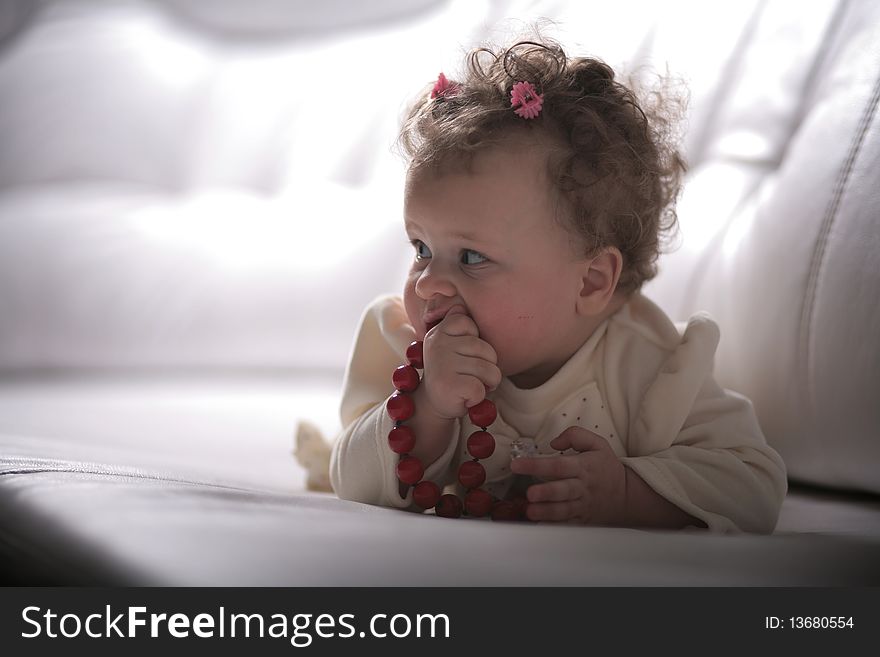 Baby girl with red beads in profile